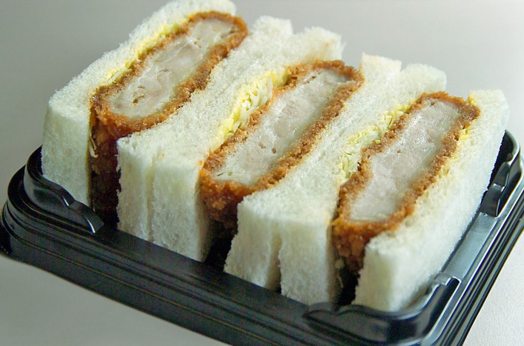 Katsu sando sandwich in container - 3 pieces of white bread, plus a pork cutlet and cabbage