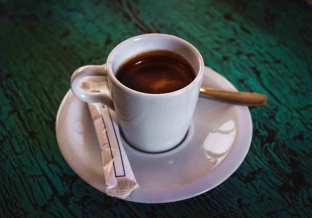 Espresso cup on saucer with sugar tube and spoon