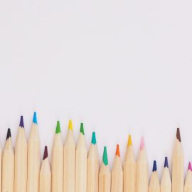 Colored pencils lined up on white background