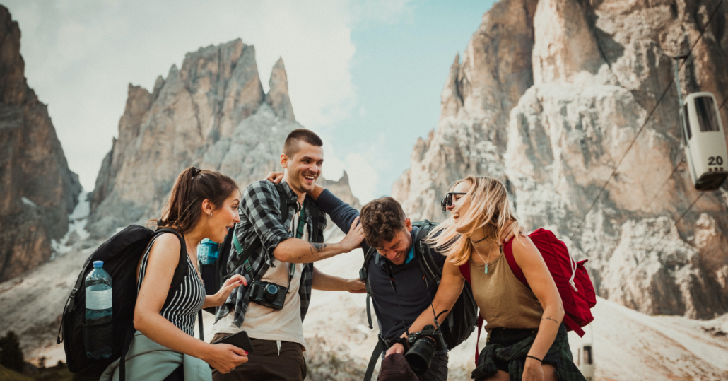 tall mountain pass and four friends hiking and taking photos